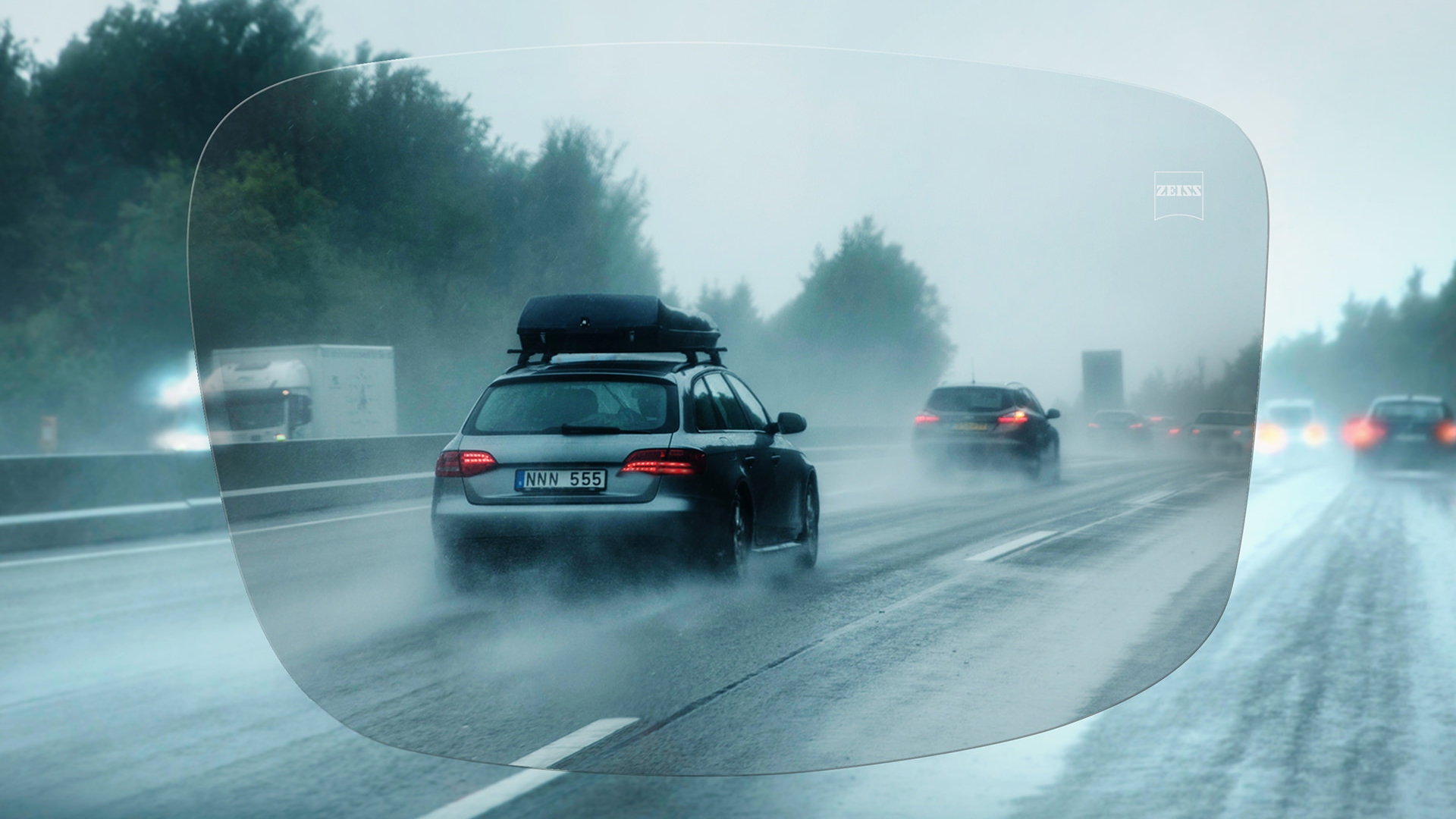 Vista a través de un lente de visión sencilla ZEISS DriveSafe de una carretera en un día de lluvia 